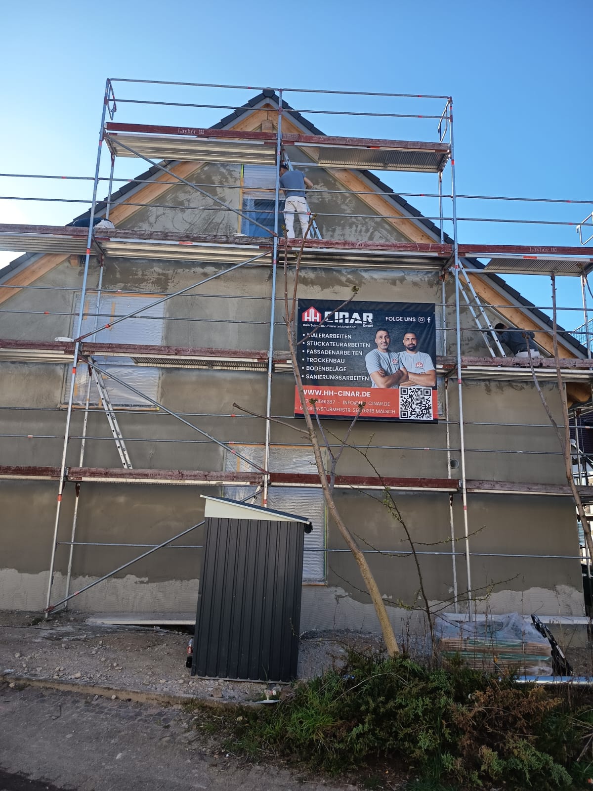 Hausfassade mit Gerüst, im Vordergrund ein Werbebanner der HH Cinar GmbH mit Harun und Hakan Cinar